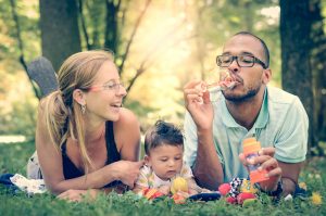 Family blows bubbles during outdoor picnic