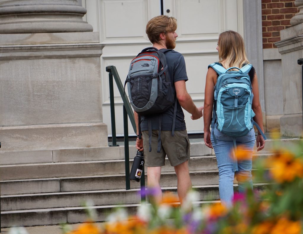 Man and women on college campus with backpacks