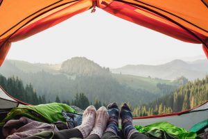 Socked feet of a couple relaxing in tent