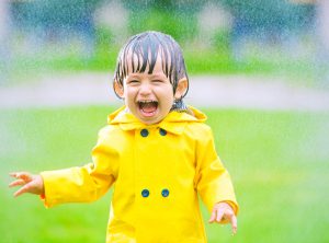 Little boy wears rain jacket in storm